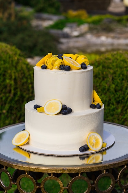 Gâteau joliment décoré sur un stand lors d'une cérémonie de mariage à l'extérieur