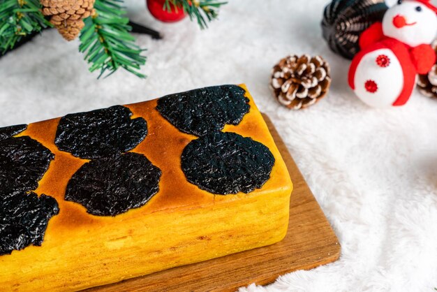 Photo gâteau lapis legit ou mille couches avec des pruneaux comme garniture et garniture de décoration de noël