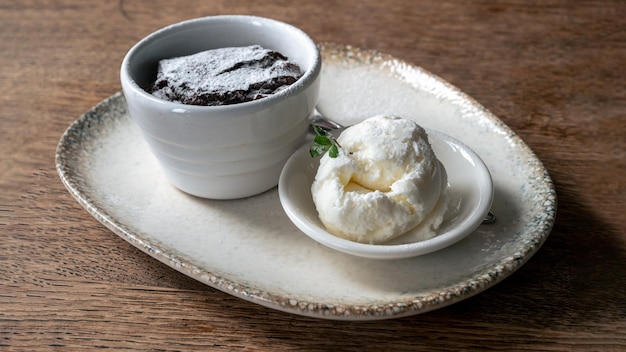 Un gâteau de lave au chocolat fondu et un morceau de crème glacée blanche servis sur une assiette blanche