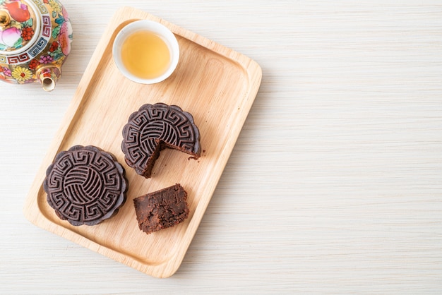 Gâteau de lune chinois saveur chocolat noir sur plaque de bois