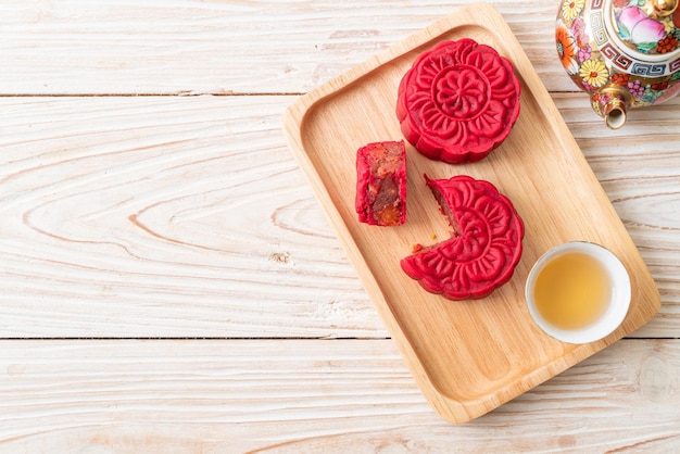 Gâteau de lune chinois saveur de haricots rouges aux fraises sur plaque de bois