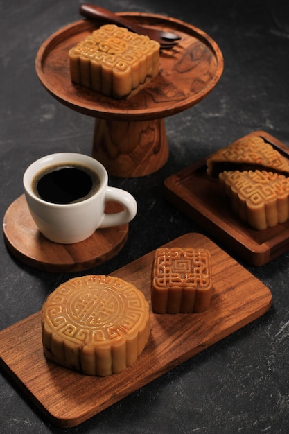 Gâteau De Lune De Forme Variée (mooncake) Snack-dessert Chinois Pendant Le Festival De La Mi-automne Du Nouvel An Lunaire. Concept Boulangerie Asiatique Rustique Noir Et Bois