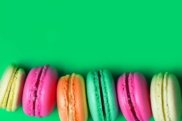 Gâteau macaron coloré sur fond vert avec espace de copie. Gros plan, vue de dessus