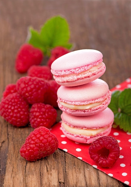 Gâteau makarons français Biscuits macaron aux framboises roses sur des planches en bois foncé