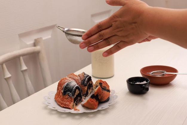 Gâteau marbré avec du café avec du sucre en poudre et un ustensile de cuisine vintage, concept de boulangerie blanche