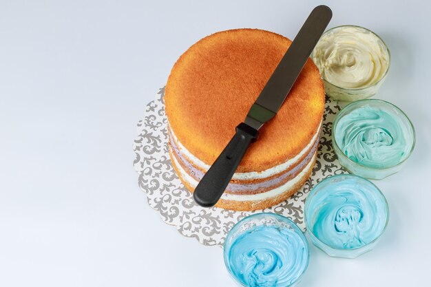 Gâteau de mariage avant décoration avec glaçage bleu à la spatule.