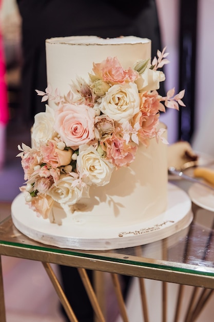 Gâteau de mariage blanc avec des fleurs et des myrtilles