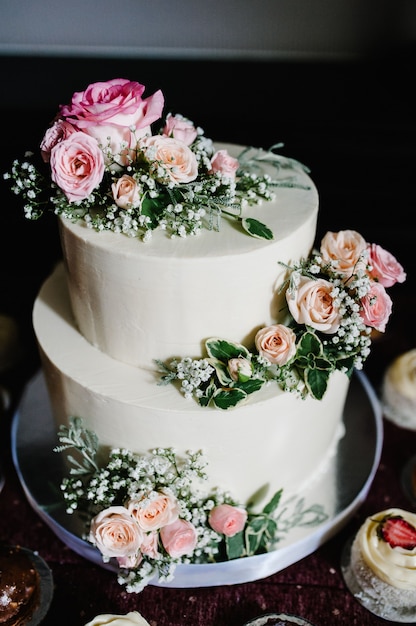 Gâteau de mariage blanc avec des fleurs roses