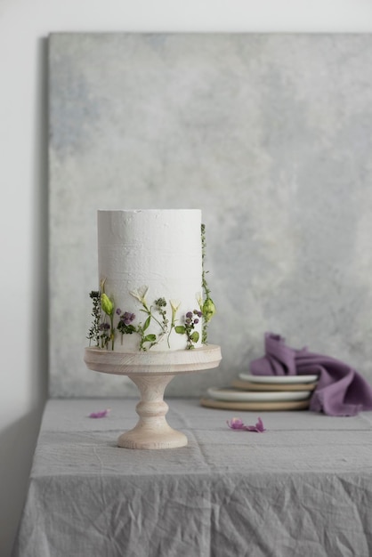 Gâteau de mariage blanc avec lillac et fleurs vertes