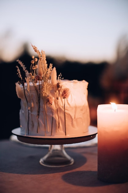 Gâteau de mariage Boho sur la table le soir