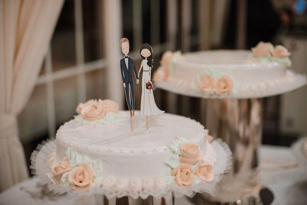 Gâteau de mariage avec des figurines drôles d&#39;époux et épouse.