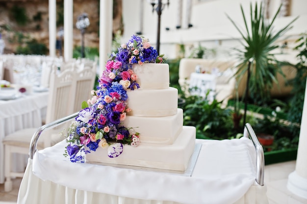 Gâteau de mariage avec des fleurs violettes et violettes au hall