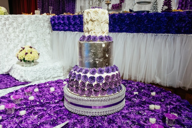 Gâteau de mariage floral blanc sur fond intérieur de restaurant