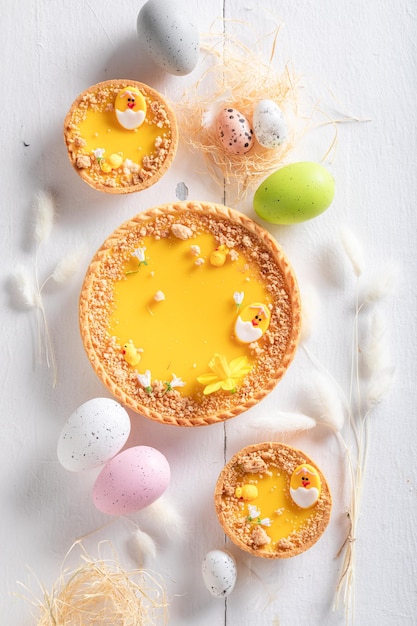 Gâteau Mazurka fait maison entouré de fleurs printanières et d'œufs