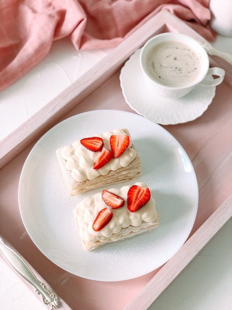 Gâteau Milfey avec crème et fraises et tasse de café