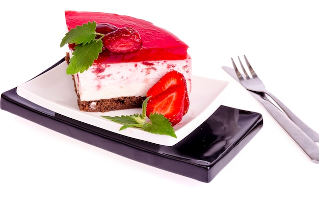 Photo gâteau mousse aux fraises d'été avec des baies fraîches sur fond blanc.