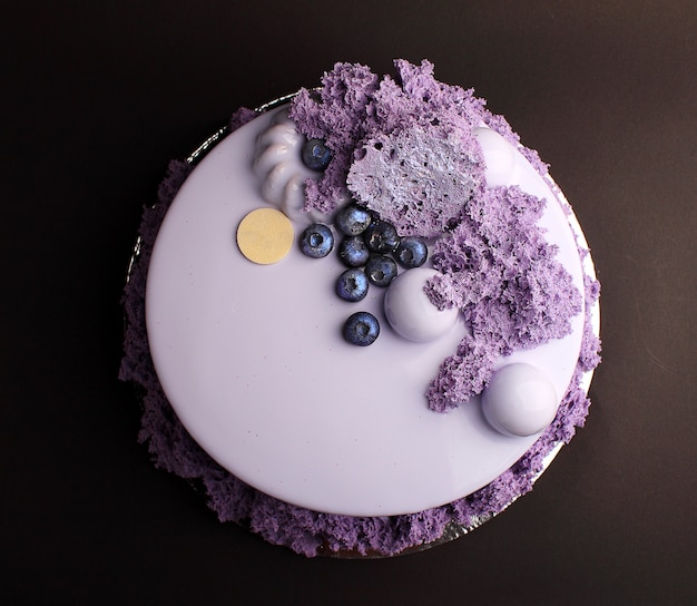 Gâteau à la mousse de baies avec glaçure miroir. Avec décor à la myrtille et au caramel