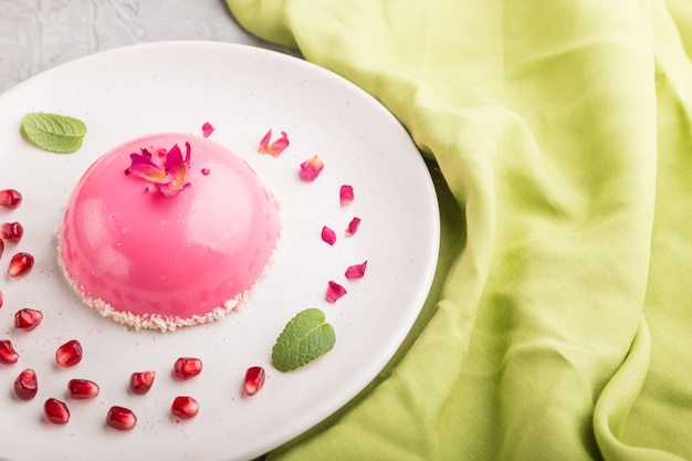 Gâteau mousse rose à la fraise sur une surface en béton gris. vue latérale, mise au point sélective.