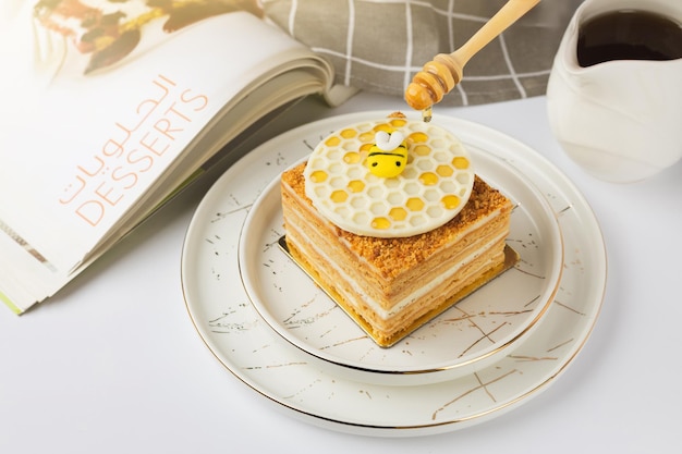 Photo gâteau napoléon avec du miel sur un fond blanc
