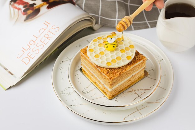 Photo gâteau napoléon avec du miel sur un fond blanc