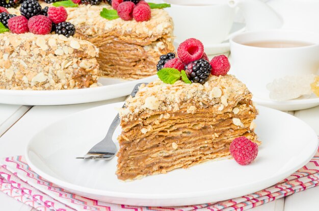 Gâteau Napoléon festif avec crème au chocolat et baies sur le dessus