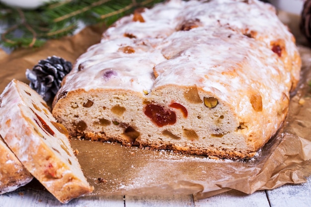 Gâteau de Noël allemand Stollen avec fruits secs et noix se bouchent sur la table