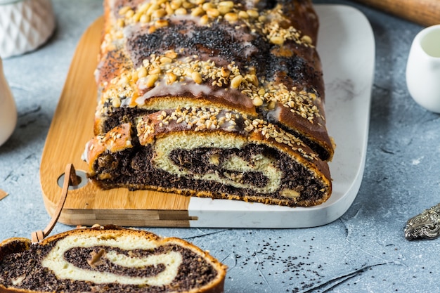 Gâteau de Noël aux graines de pavot, gâteau aux graines de pavot tranché recouvert de glaçage et décoré de raisins secs et de noix. Gâteau de Noël traditionnel de Pologne. Plat de Noël. La veille de Noël. Noël