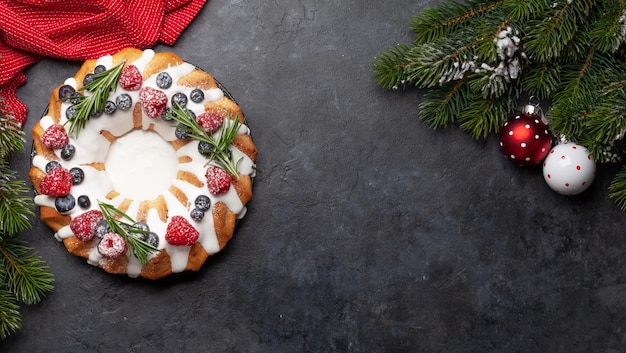 Un gâteau de Noël avec des baies et du romarin.