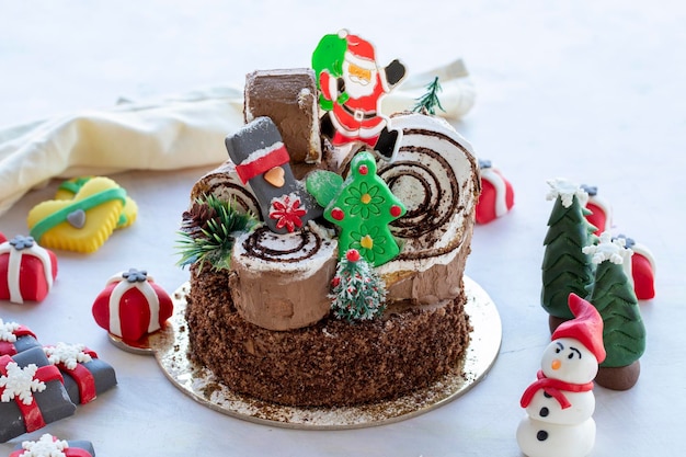 Gâteau de Noël préparé avec de la pâte à sucre Avec le sapin de Noël du père noël et des figurines cadeaux dessus