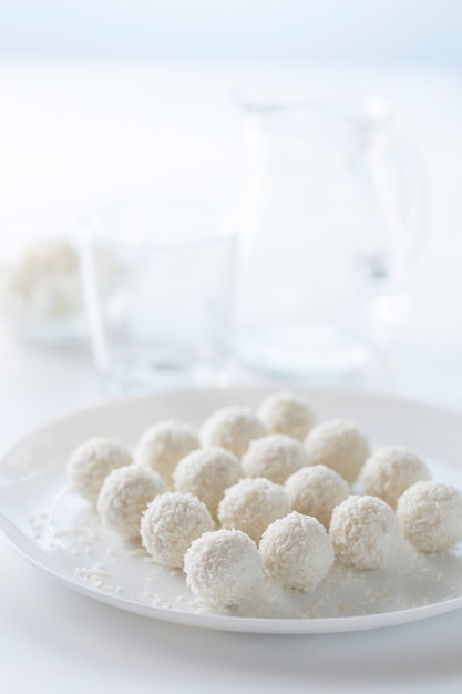 Gâteau de noix de coco de dessert et lait dans une cruche sur un fond clair