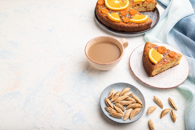 Gâteau à l'orange aux amandes et une tasse de café sur un fond de béton blanc. Vue de dessus, espace copie.