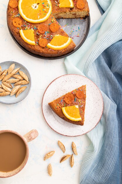 Gâteau à l'orange aux amandes et une tasse de café sur un fond de béton blanc. Vue de dessus, gros plan.