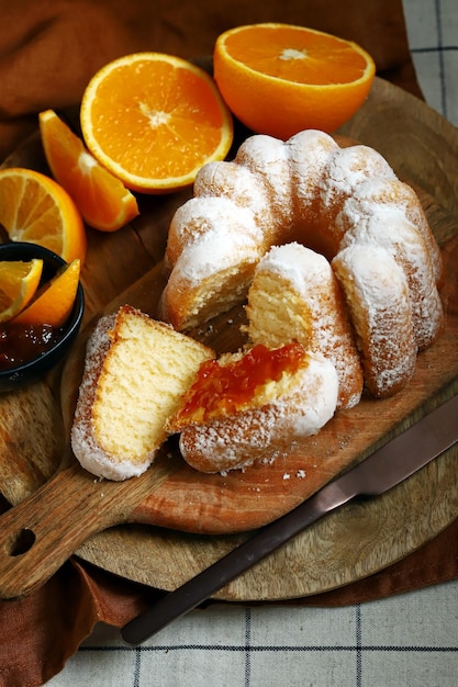 Gâteau orange doux et moelleux avec du sucre en poudre sur une planche de bois