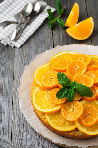 Gâteau à l'orange et à la mandarine avec polenta, à l'envers sur la vieille surface en bois. Mise au point sélective.