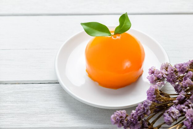 Gâteau orange sur une table en bois blanche