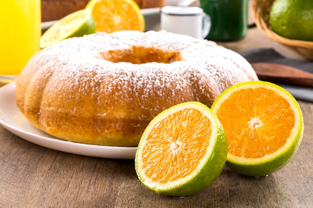 Gâteau à l'orange sur la table avec fruits et jus.