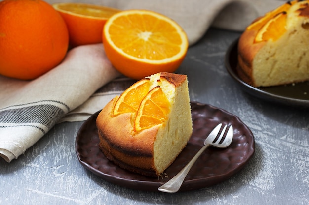 Gâteau à l'orange avec des tranches d'orange sur un béton.