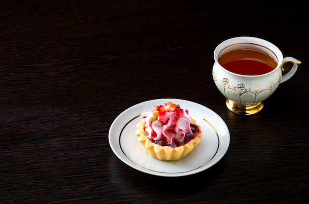 Gâteau de panier avec de la confiture dans l'assiette et du thé