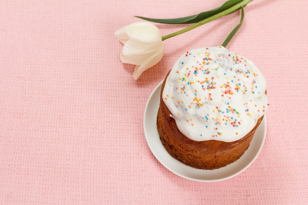 Gâteau de Pâques sur une assiette avec une fleur de tulipe sur le sac rose