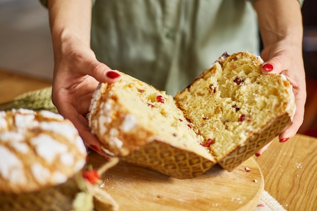 Gâteau de Pâques coupé à la main par une femme sur une table rustique en bois