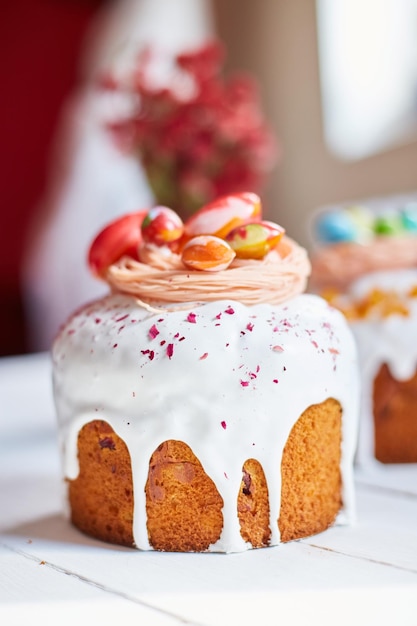 Gâteau de Pâques avec décoration d'oeufs en chocolat sur une table en bois blanc la maison de vacances Joyeuses Pâques