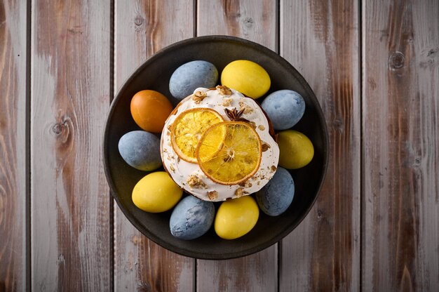 Gâteau de pâques fait maison et oeufs peints multicolores sur plateau noir