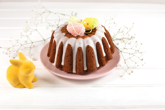 Gâteau de Pâques et lapin de Pâques et sur un bureau en bois blanc