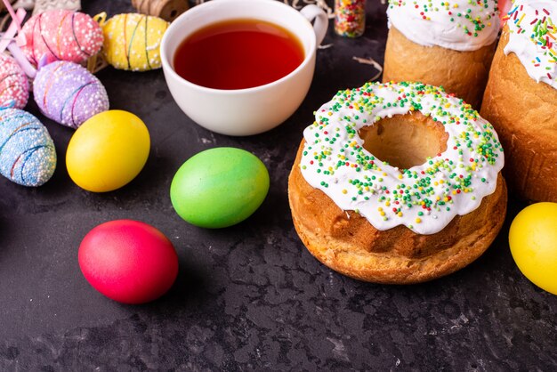 Gâteau de Pâques et oeufs colorés sur fond sombre