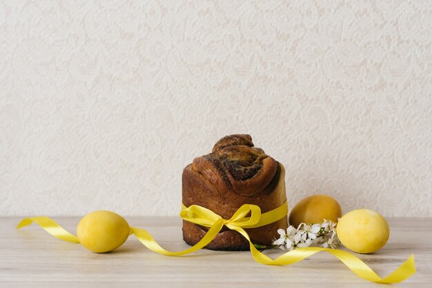 Gâteau de Pâques, oeufs peints en jaune et fleurs sur une table beige. Saison des vacances de printemps. table de fête traditionnelle. Espace de copie