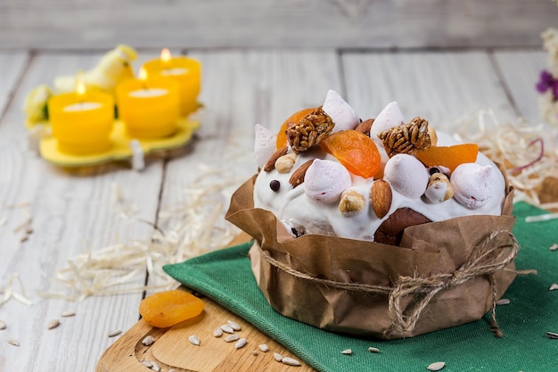 Gâteau de Pâques pain décoré de bonbons abricots secs et graines de tournesol sur fond de bois Concept de vacances