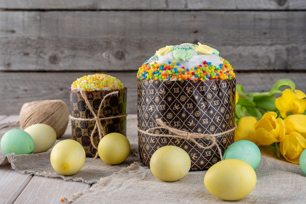 Gâteau de Pâques, peint des oeufs avec des tulipes sur un fond en bois ancien rustique.