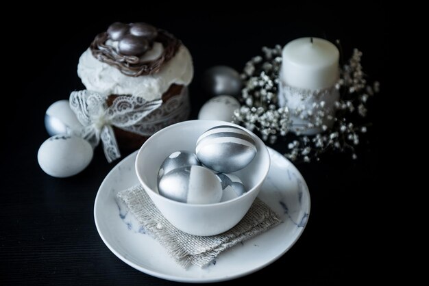 Gâteau de Pâques traditionnel avec bougies d'œufs peints en argent et saule sur fond noir Mise au point sélective