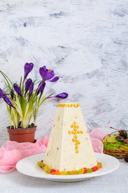 Gâteau de Pâques traditionnel avec des fruits confits et des œufs en chocolat, des fleurs de printemps crocus sur le fond clair des vacances.