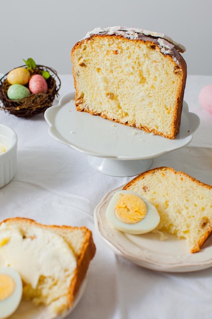 Le gâteau de Pâques en tranches sur un support blanc Des morceaux de tarte aux œufs se trouvent à côté sur la table